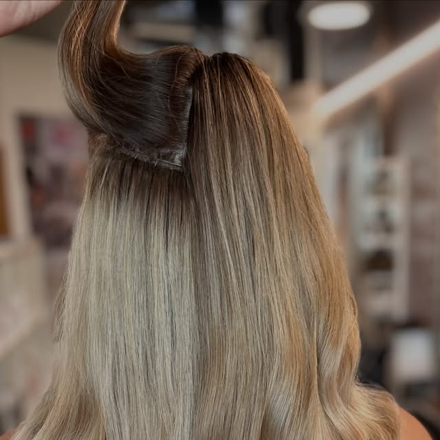 Tape-in-Extensions werden gesetzt, Rückenansicht